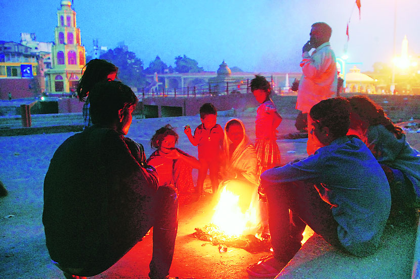 गोदा पात्रालगत शेकोटीचा आनंद घेताना युवक. (छाया - मयूर बारगजे)