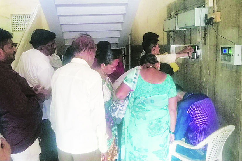 कल्याण-डोंबिवली पालिकेतील कार्यान्वित केलेले बायोमेर्ट्ीक मशीनवर कर्मचाऱ्यांची हजेरी नोंदवताना. 