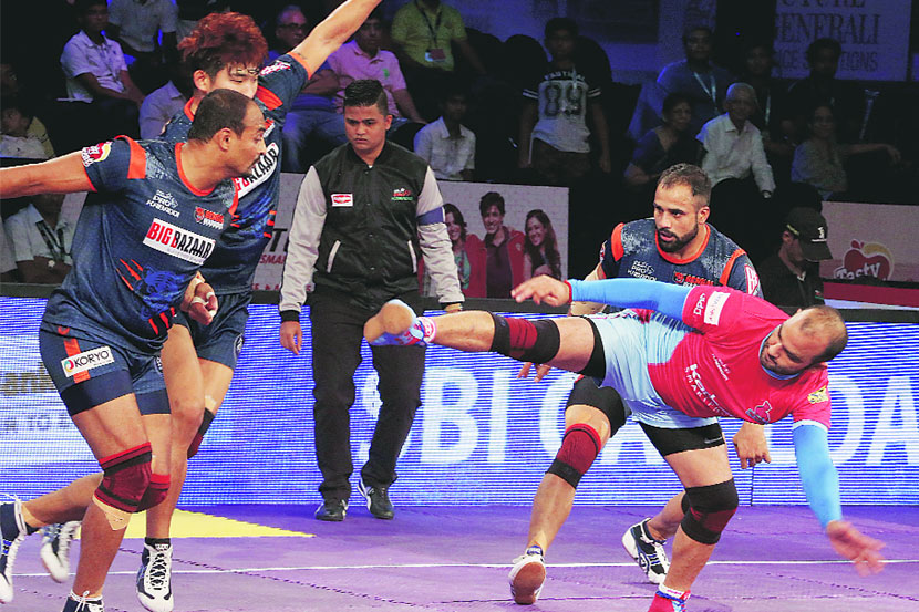 तेलुगू टायटन्सच्या राहुल चौधरीची पकड करताना यु मुंबाचे क्षेत्ररक्षक.