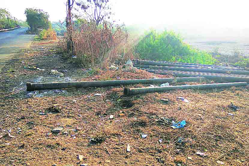 रस्त्याच्या कडेला धुळखात पडलेल्या जलवाहिन्या