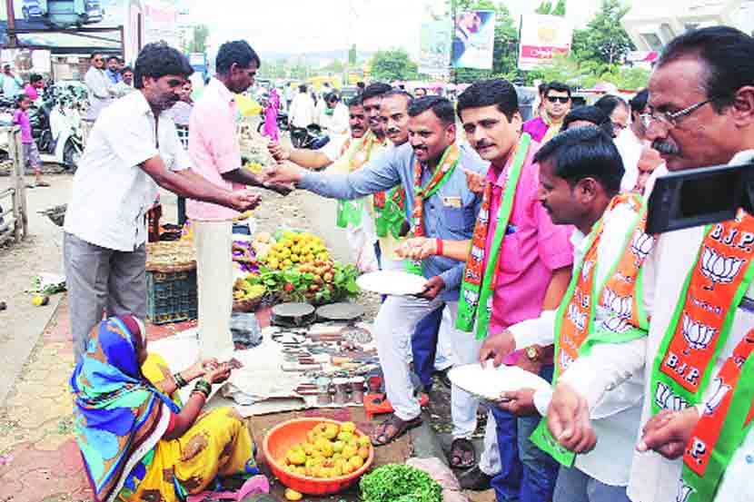 शेतकऱ्यांची कर्जमुक्ती जाहीर केल्यावर भाजपच्या विनायक पावसकर आणि त्यांच्या कार्यकर्त्यांनी सातारा शहरात नागरिकांना साखर वाटून आनंद साजरा केला. (छाया- संजय कारंडे)