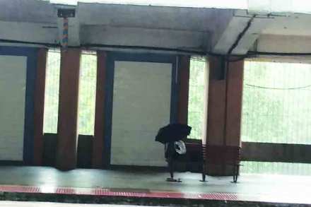 कौपरखेरणे फलाटांवर छत्री घेवून बसलेला प्रवासी. कौपरखेरणे फलाटांवर छत्री घेवून बसलेला प्रवासी.