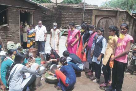पूरग्रस्त बामणी या गावात पूरग्रस्तांच्या घरातील चिखलाने माखलेली भांडी स्वच्छ करीत असताना महाविद्यालयीन विद्यार्थिनी.