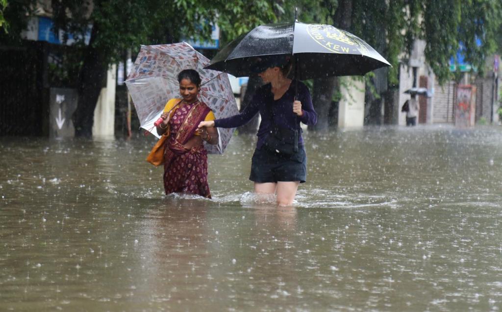 अंधेरीमधील एस व्ही रोडवर साचलेल्या पाण्यातून महिला मार्ग काढताना (Express Photo: Nirmal Harindran)