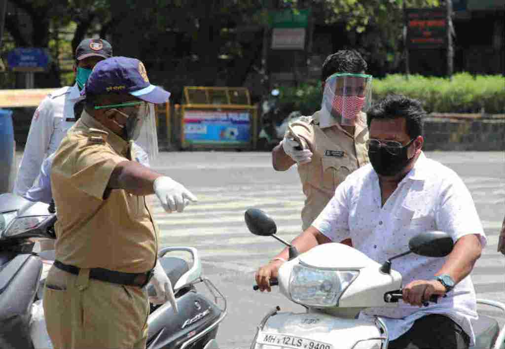 बाहेर पडणाऱ्या नागरिकांची चौकशी करताना पोलीस.