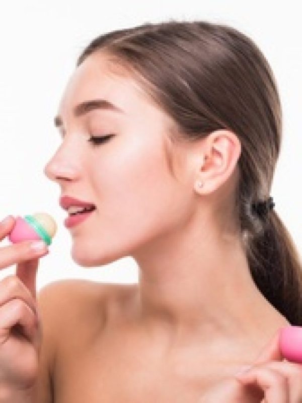 cropped-young-woman-applying-hygienic-lip-balm-white-wall_231208-1426.jpg