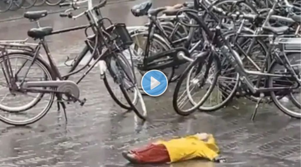 Child enjoying rain while lying on the road