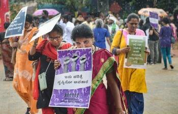 उद्यानात नागरिक, कार्यकर्ते आणि विविध महिला संघटनांच्या सदस्या भर पावसात हातात पोस्टर घेऊन उभ्या होत्या.