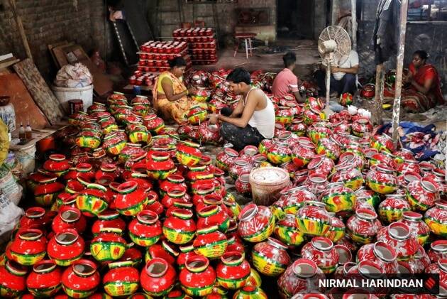 अहमदाबादमधील भांडी कार्यशाळेत नवरात्रीच्या विक्रीपूर्वी सजावटीच्या मातीची भांडी किंवा मटके रंगवण्यात गुंतलेले कामगार. (निर्मल हरिंद्रनचे एक्सप्रेस फोटो)