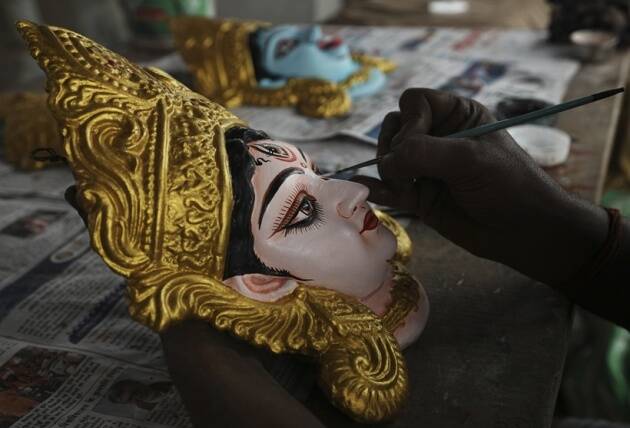 एक कारागीर हैदराबाद येथे दुर्गा पूजा उत्सवापूर्वी दुर्गा देवीची मातीची मूर्ती रंगवत आहे. (AP)