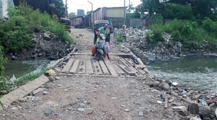Passengers travel dangerously through the drain in Kopar East in Dombivli Passengers travel dangerously through the drain in Kopar East in Dombivli