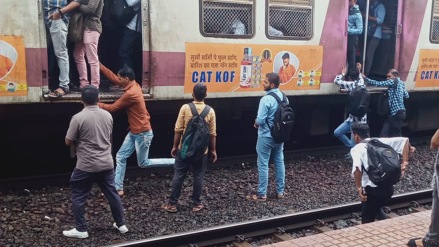 Passengers board local opposite door standing railway line diva railway station