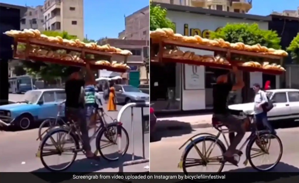 man carrying heavy tray of breads on his head while cycling in busy traffic in egypt people surprised watch