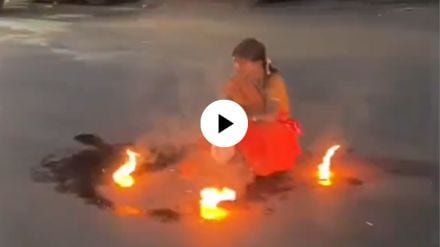 what is going on a woman sitting on middle of the road and doing weird things