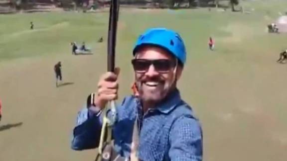 A shot from the video shows multiple people running through the meadow.