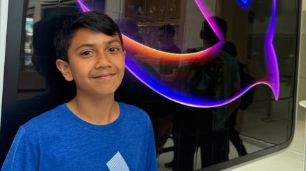 Teenage Indian coder showcasing SpendSmart app interface on smartphone