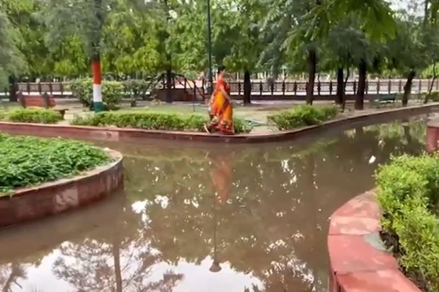 गाझियाबादसारख्या एनसीआर भागातील उद्यानात पाणी साचल्यामुळे प्रभातफेरीसाठी आलेले लोक कठड्यावरून चालताना दिसले. (Image: IANS)
