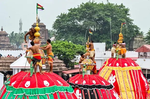 रथयात्रेच्या पूर्वसंध्येला पुरीतील सेवक रथांवर घुमट बसवण्याचे पवित्र काम करीत आहेत. हे दृश्य पाहण्यासाठी हजारो भक्त एकत्र जमले आहेत. (छायाचित्र स्रोत: पीटीआय)