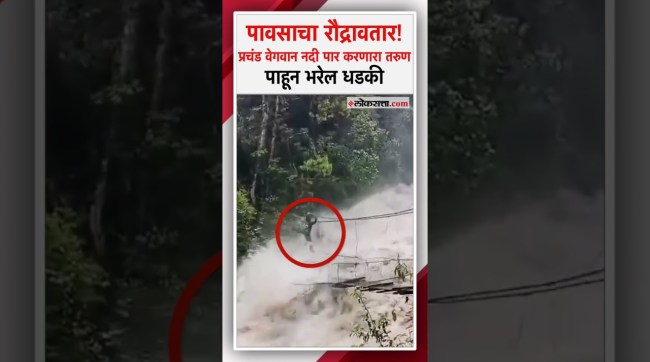 A young man crossed a suspension bridge in heavy rain.