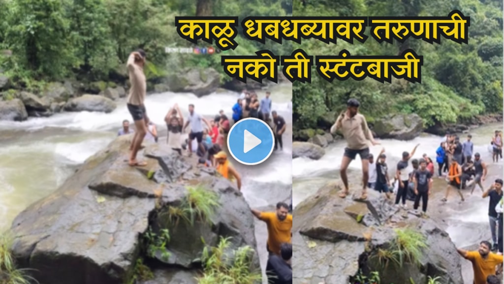 Young man performing dangerous dance on rocks at Kalu Waterfall
