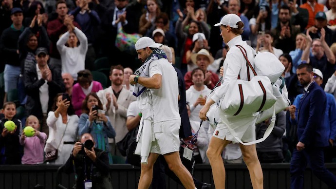 Jannik Sinner carries injured Grigor Dimitrov's bags