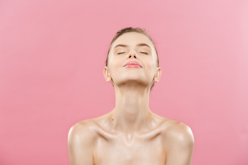 Beauty Concept - Beautiful Woman with Clean Fresh Skin close up on pink studio. Skin care face. Cosmetology.