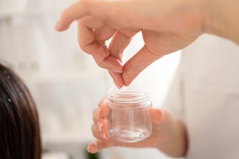 Woman hand holding her long hair with looking at damaged splitting ends of hair care problems