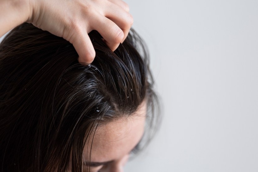 Woman hand holding her long hair with looking at damaged splitting ends of hair care problems