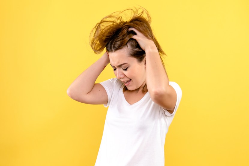Woman hand holding her long hair with looking at damaged splitting ends of hair care problems