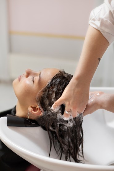 Woman hand holding her long hair with looking at damaged splitting ends of hair care problems