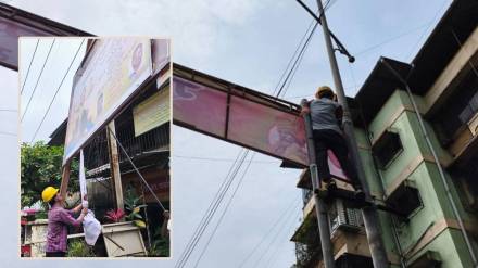 फ प्रभागातील फलक काढताना फेरीवाला हटाव पथकातील कामगार.