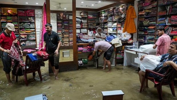 दुर्गापूजेच्या तयारीदरम्यान दुकानांमध्ये पाणी शिरल्यानंतर दुकानदारांनी आपला माल वाचविण्याची धडपड केली. (पीटीआय)