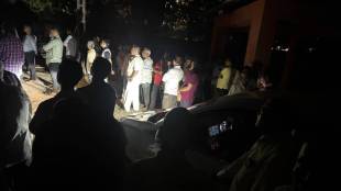 Funeral in the cemetery under the light of car headlights