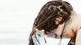 Woman washing hair with hot water affecting hair health and shine.