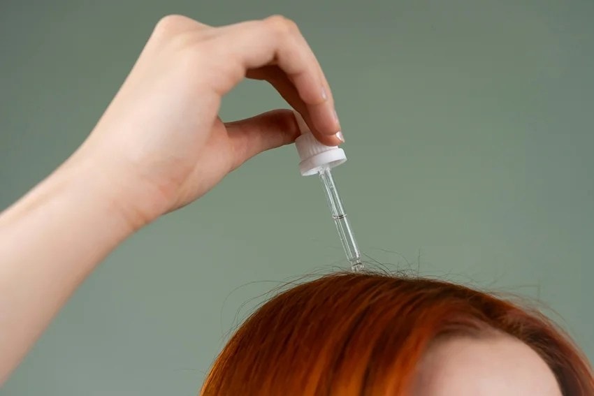 Woman washing hair with hot water affecting hair health and shine.