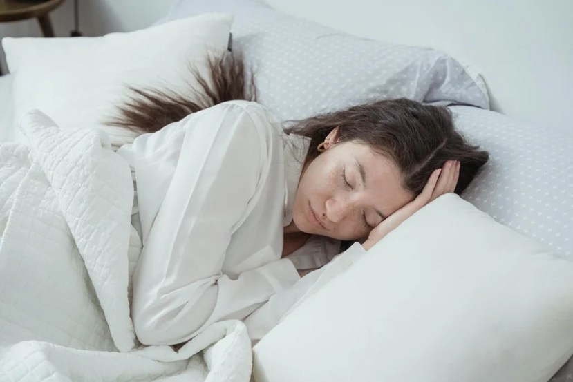 Woman sleeping peacefully, symbolizing why women need more sleep