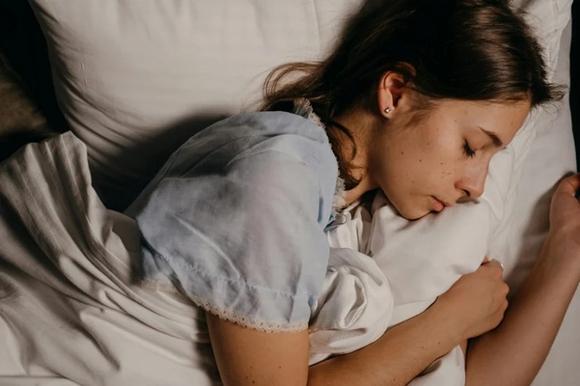 Woman sleeping peacefully, symbolizing why women need more sleep