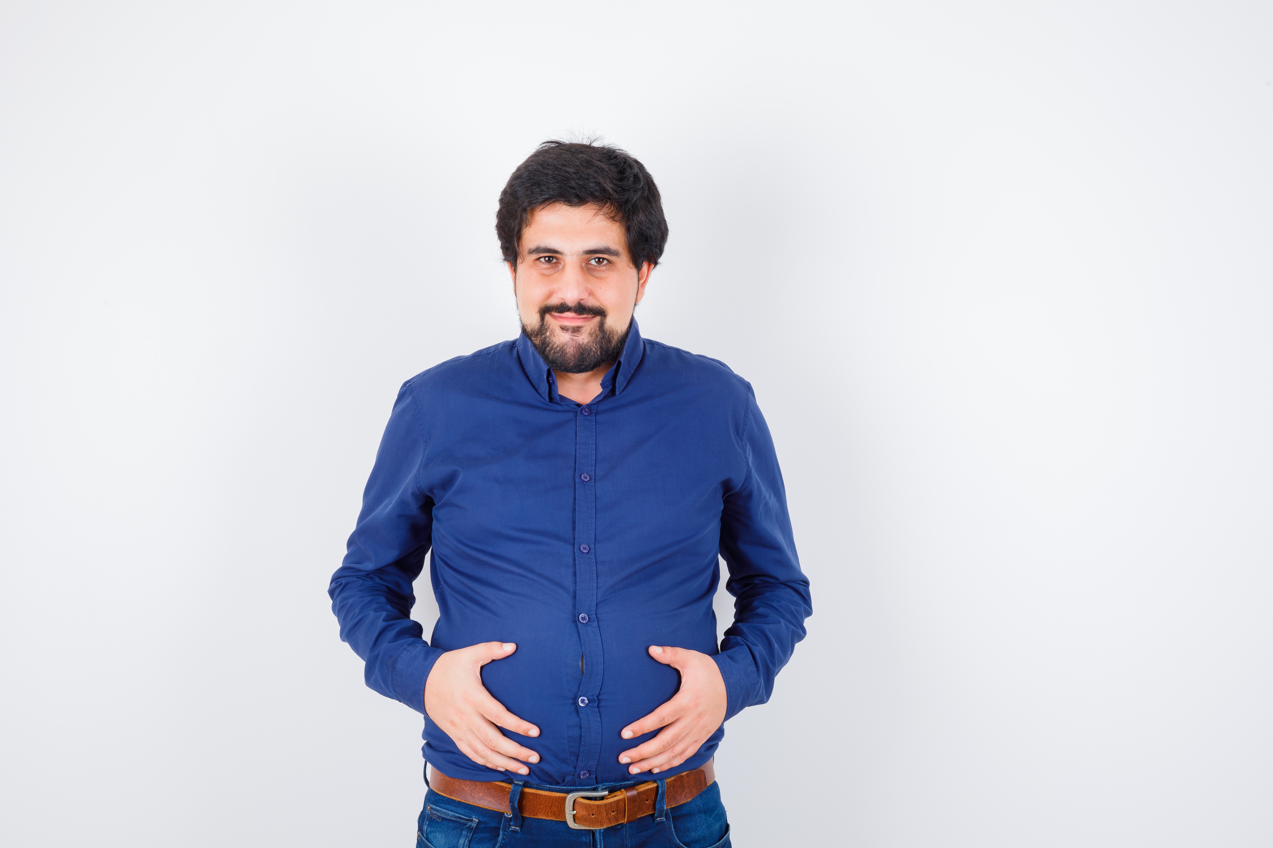 Indian holding stomach showing belly fat and digestive health issue