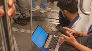 Man work on laptop sitting Delhi Metro flooR