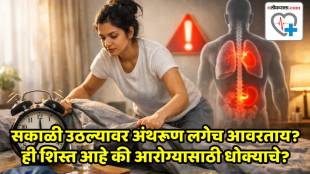 A person making a bed in the morning with sunlight coming through the window.