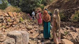 Women climb down steep rocky slopes carrying empty pots to fetch drinking water from natural sources in the remote tribal hamlets of Maharashtra’s Nandurbar district.-(Express photo by Purnima Sah)