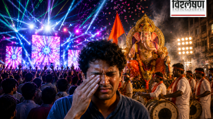 A distressed man covers his eye amid a crowded Ganesh festival procession, with a large Ganesh idol, drummers, colorful lights, confetti, and loud celebrations in the background.