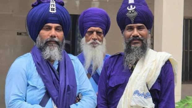 Nihang Sikh in traditional blue attire and turban with traditional weapons